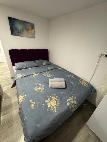 a bed with a blue comforter with a towel on it at Georgeous lux apartment # purple in Foča