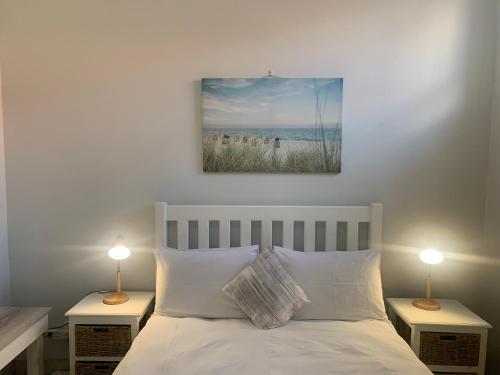 a bedroom with a bed with two lamps on tables at OysterCatcher Self-Catering Accommodation Strand in Cape Town