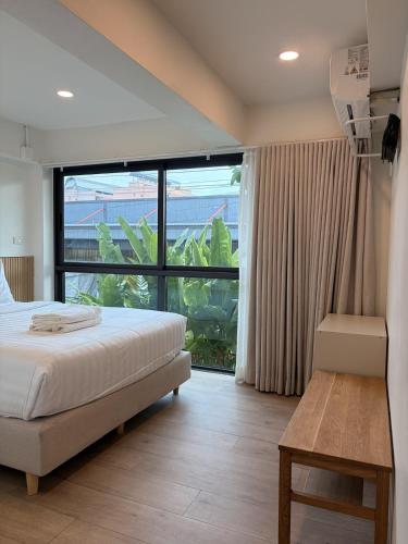 a bedroom with a bed and a large window at 2 Bed & 2 Bath Suite, 2nd floor in Ban Bang Toei (1)