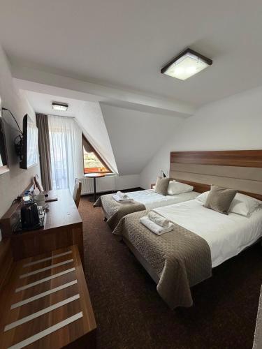 a hotel room with two beds and a desk at Hotel Beskidian in Węgierska Górka