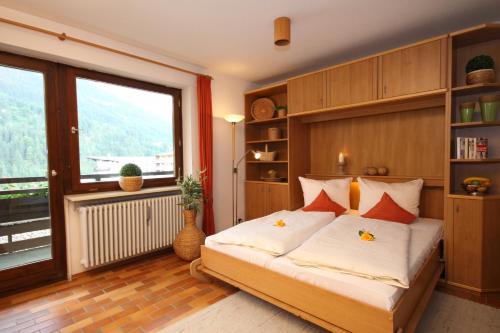 a bedroom with a bed and a large window at Sporthotel Walliser in Hirschegg