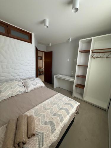 a bedroom with a bed and a book shelf at Apartamento Guarapari temporada in Guarapari