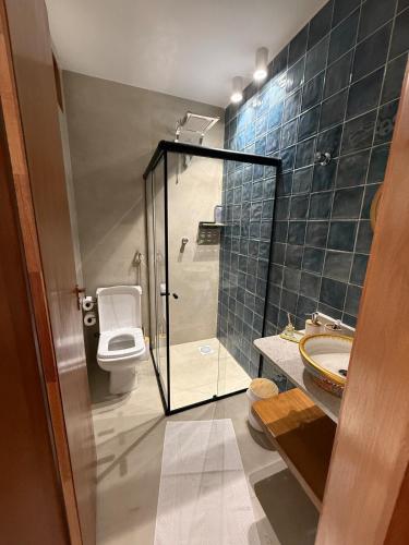a bathroom with a shower and a toilet and a sink at Apartamento Guarapari temporada in Guarapari