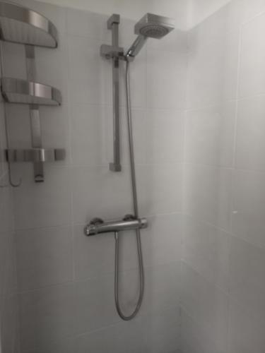 a shower with a shower head on a wall at Chambre d'hôtes du Carrousel in La Teste-de-Buch