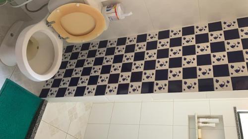 a bathroom with a toilet and a checkered floor at Casa Com 2 Quartos Barra Serinhaem - BA in Ituberá