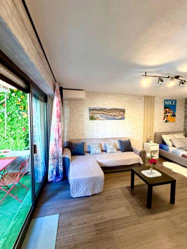 a living room with a couch and a table at studio city center beach side free paddle beautiful terrace in Nice