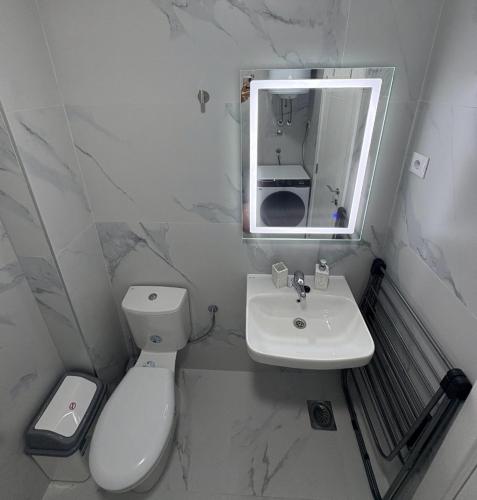 a white bathroom with a toilet and a sink at D&M Lux2 in Podgorica