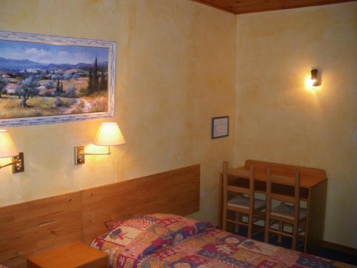 - une chambre avec un lit et une peinture murale dans l'établissement Hôtel Saint Clair, à Saint-Étienne-les-Orgues