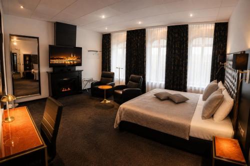 a hotel room with a bed and a fireplace at Hotel Le Beau Rivage in Middelburg