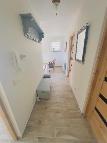 a hallway with white walls and a wooden floor at Apartamenty na Pięknej 24-2 in Nowy Sącz
