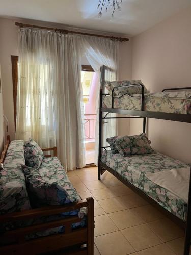 two bunk beds in a room with a window at Aqua Mare Seaside Experience in Pyrgadikia