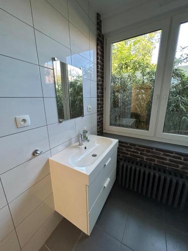 a bathroom with a white sink and a mirror at La Parenthèse Gîte in Créhange