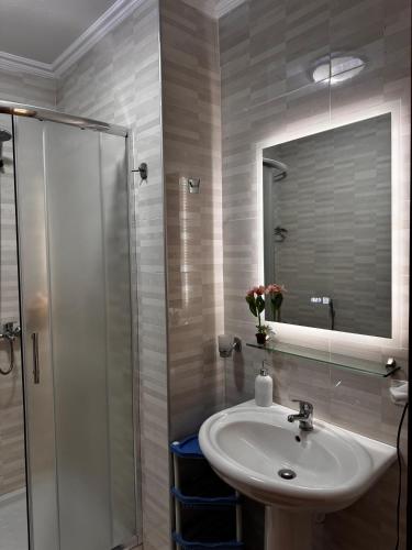 a bathroom with a sink and a shower with a mirror at Apartment in Durres Elio in Golem
