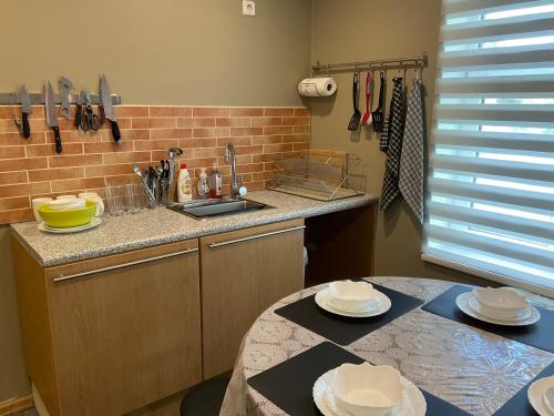 a kitchen with a sink and a table with plates on it at Jaani 2-1 Apartment in Pärnu