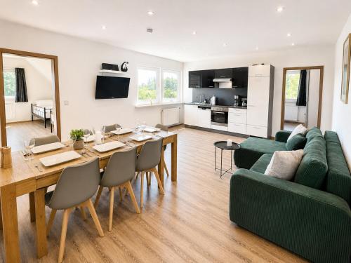 a living room with a table and a green couch at PrimeLoft Apartments am Kurpark in Braunlage