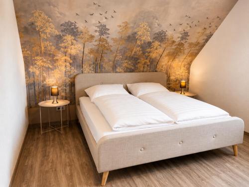 a bedroom with a bed with a painting on the wall at PrimeLoft Apartments am Kurpark in Braunlage