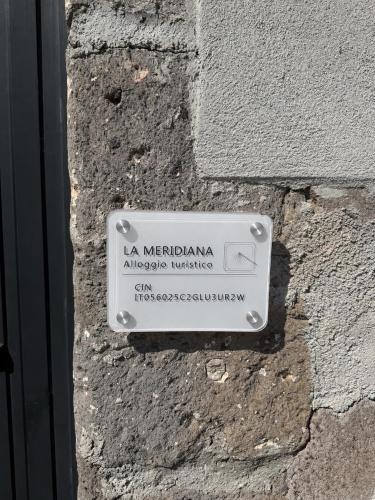 a white sign on the side of a building at La Meridiana in Faleria