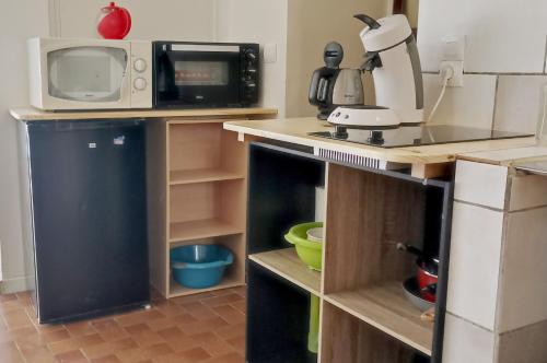 a kitchen with a counter with a microwave and a sink at Studio privé - maison de village in Valensole