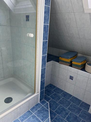 a bathroom with a shower with blue tiles at Panoramic Alpine Residence in Eisenerz