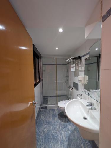 a bathroom with two sinks and a shower at Hotel Trefacio in Zamora