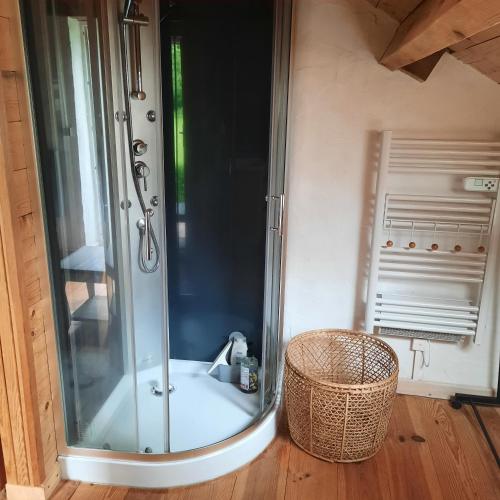 a shower in a bathroom with a basket at Chambre d'hôte Le Châtaignier in Planchez