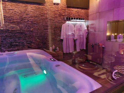a bathroom with a large tub with purple lighting at La Suite in La Calamine