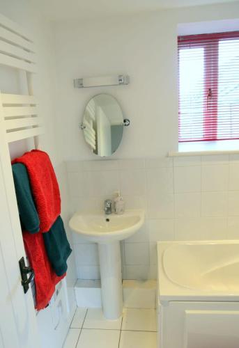 a white bathroom with a sink and a mirror at Gap Cottage on Hadrian's Wall in Brampton