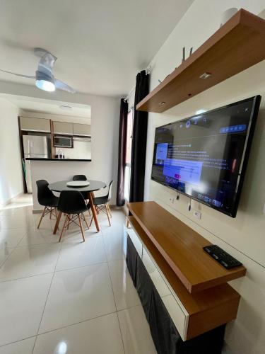 a living room with a table and a large screen television at 05-Conforto e Modernidade com piscina e garagem in São Leopoldo