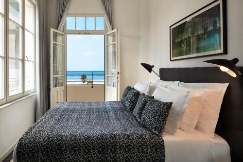 a bedroom with a bed with a view of the ocean at Renoma in Tel Aviv