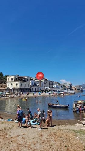 a group of people on a beach with a red frisbee at Addor 'e Mare in Bacoli