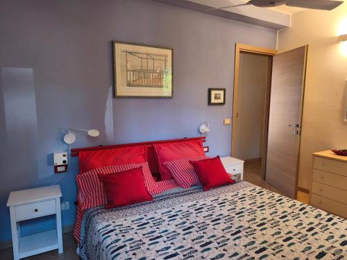 a bedroom with a large bed with red pillows at La grande terrazza di Capo d'Arco in Capo D'Arco