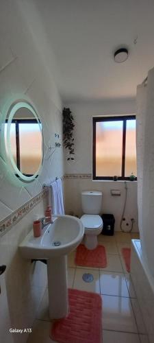 a bathroom with a sink and a toilet and a mirror at Sunrise house in Ribeira Grande
