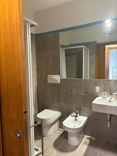 a bathroom with a toilet and a sink and a mirror at Taormina Belu Beach Apartment in Letojanni