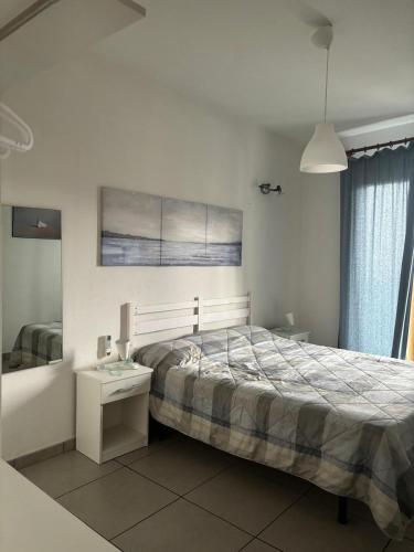 a bedroom with a bed and a table and a mirror at Taormina Belu Beach Apartment in Letojanni