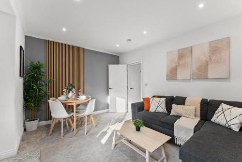a living room with a couch and a table at Spacious Modern 2BR - Parking - Workspace Area, Ideal for Contractors & Long Stays - NordStay in Amley