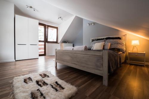ein Schlafzimmer mit einem großen Bett und einem Teppich in der Unterkunft JosepHome in Zakopane
