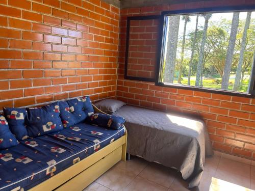 a room with a bed and a brick wall at Bella Vite in São José dos Pinhais
