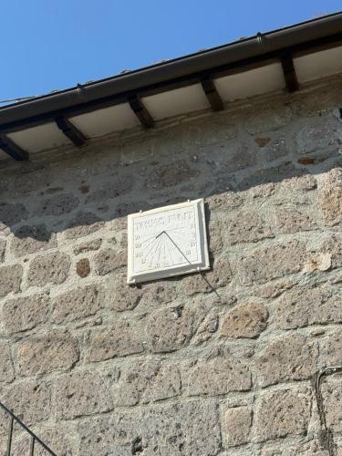 a clock on the side of a brick wall at La Meridiana in Faleria