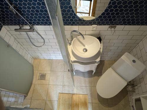a bathroom with a sink and a toilet and a mirror at Stevns Birkevang The Silo - Rural refuge in Faxe
