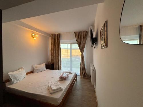 a bedroom with a bed and a window at Pensiunea SAUVAGE in Corbu
