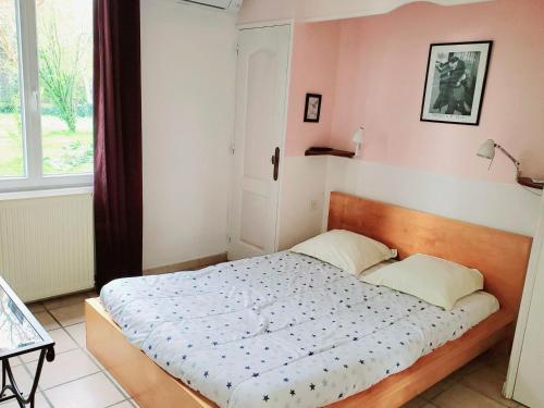 a bedroom with a bed in a room with a window at La Caleche in Bégadan