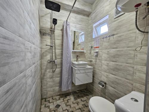a bathroom with a toilet and a sink and a shower at Imeri Hotel in Ureki