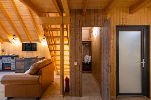 a living room with a staircase in a log house at A Frame by Tinutul Marului in Voineşti