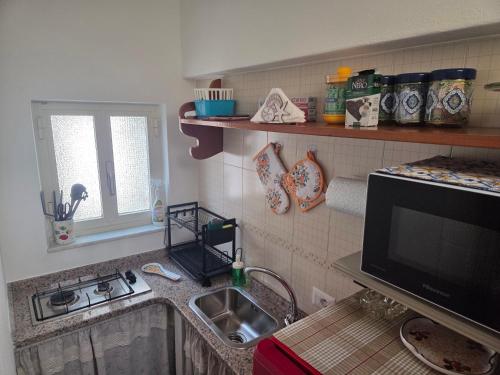 a kitchen with a sink and a stove and a counter top at Conchiglia in Lipari