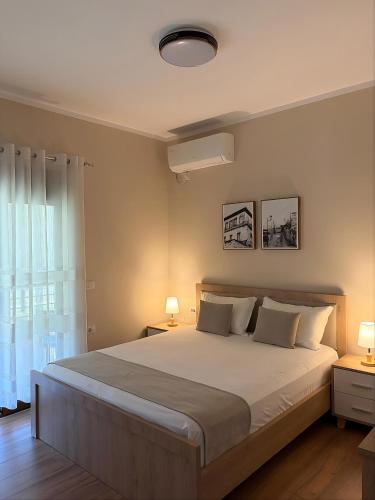 a bedroom with a large bed and a window at Villa Tabaku in Berat
