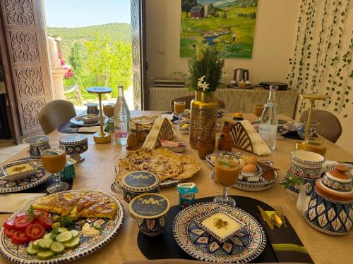 a table with plates of food and drinks on it at 1001-Nights Palace in Nebeur