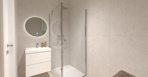 a white bathroom with a shower and a sink at Villa La Pollo in Senec