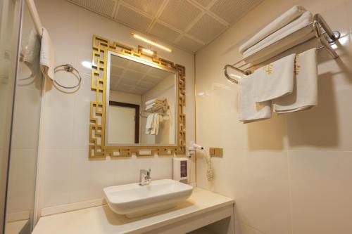 a white bathroom with a sink and a mirror at Vera Vista Hotel in Ipekyolu