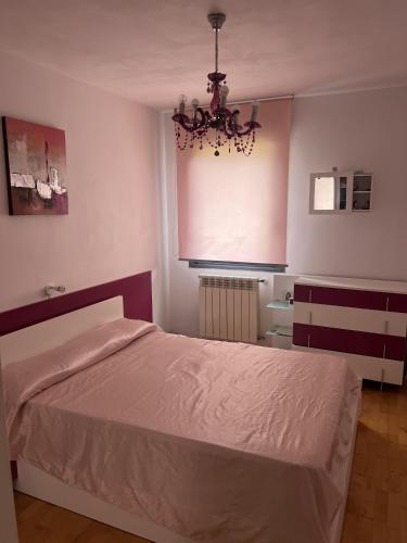 a bedroom with a bed and a chandelier at Bajo con jardín in Miengo