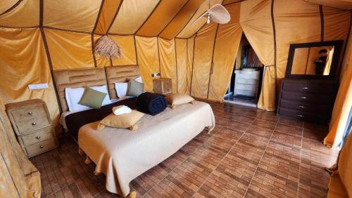 a bedroom with a bed in a tent at Shining Luxury Camp in Merzouga